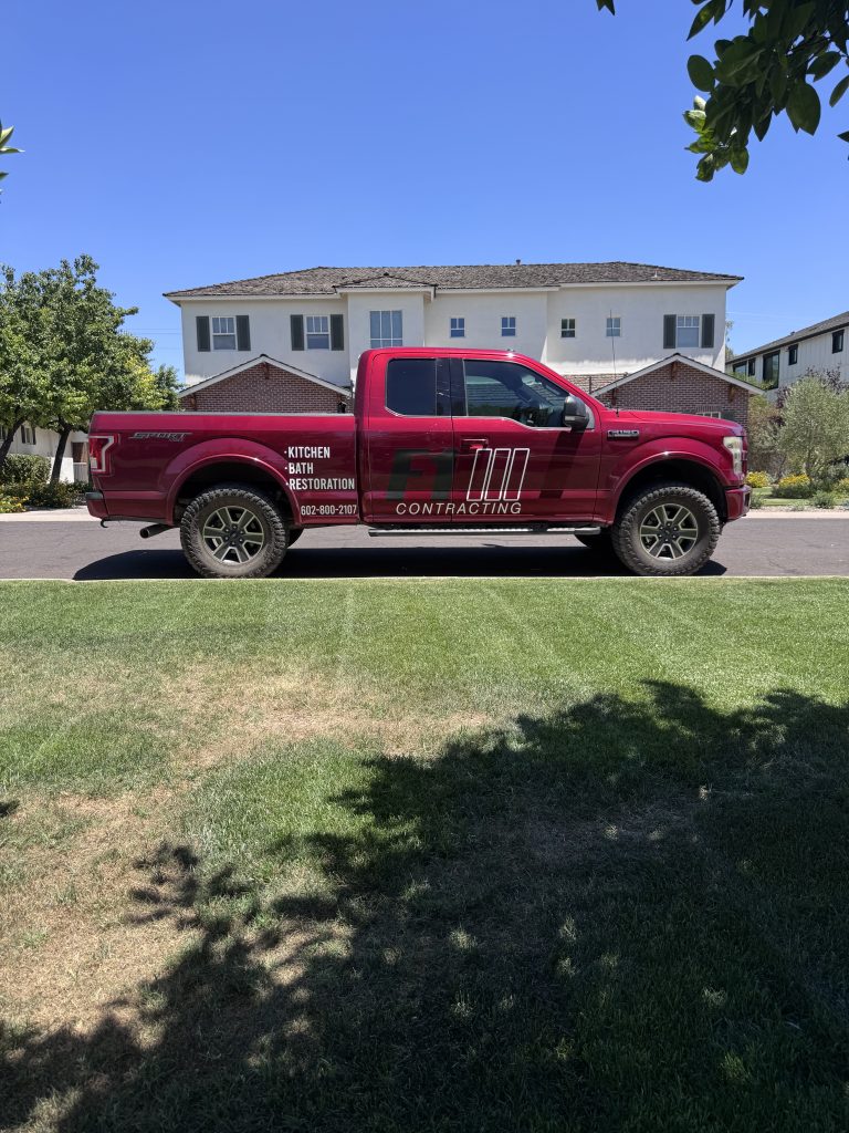 Red F1 Contracting truck with company branding parked outside a home